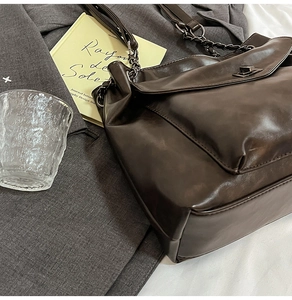 Dettaglio borsa shopper vintage marrone scuro con pelle lucida e chiusura a girello argento