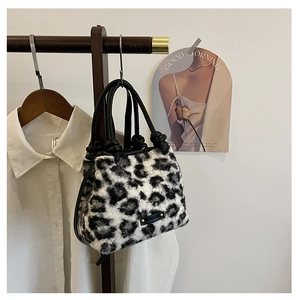 Dettaglio borsa leopardata in peluche con manico in pelle su appendiabiti in legno