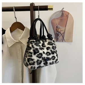 Dettaglio della borsa leopardata in ecopelliccia con manico in pelle e logo in metallo