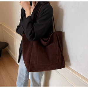 Detail of soft brown suede tote bag with slim shoulder straps and large capacity