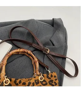 Dettaglio della borsa leopardata con manici in bambù naturale e tracolla in pelle fine