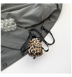 Detailed macro view of mini leopard print shoulder bag with braided rope and leather texture