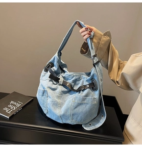 Detail der hellblauen Denim-Tasche mit Cargotaschen und schwarzen Lederakzenten