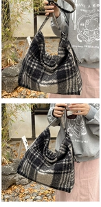 Close-up detail of the black and white plaid wool tote bag with a soft fuzzy texture