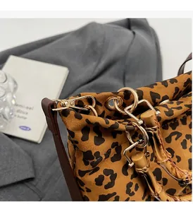 Dettaglio ravvicinato della borsa leopardata con manico in bambù e finiture dorate