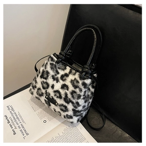 Dettaglio della borsa a secchiello leopardata in peluche con manici in pelle annodati e morbidi