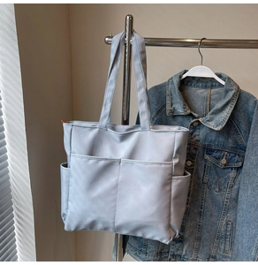 Gros plan du sac fourre-tout imperméable bleu-gris montrant les poches et le nylon