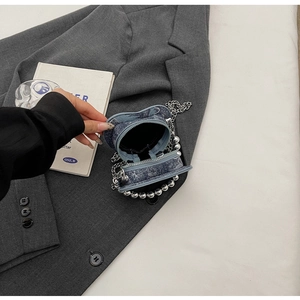 Vista dall'alto della borsa a cuore in denim blu con perline argentate su giacca