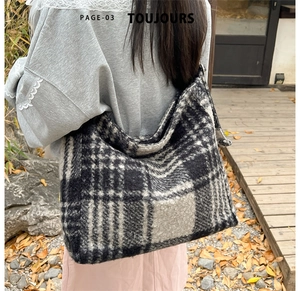 Detailed view of the thick black and white plaid tweed tote bag in an autumn outdoor setting