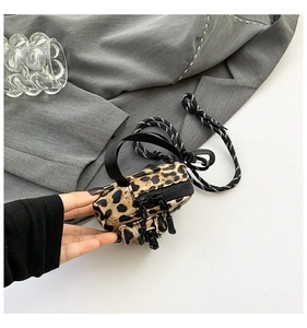 Detail view of mini leopard print crossbody bag with fuzzy texture and woven cord strap