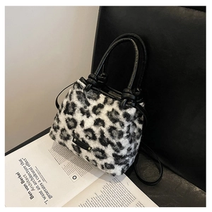 Dettaglio borsa a secchiello in finta pelliccia leopardata con manico in pelle e coulisse