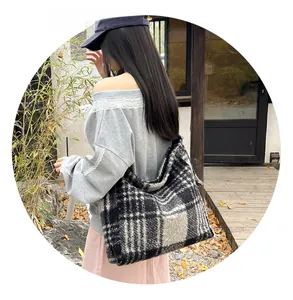 Close-up of black and white check pattern on a plush faux lamb wool large tote bag
