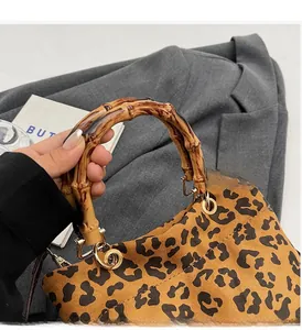 Dettaglio della borsa tote leopardata retrò con manici in bambù e fibbie dorate