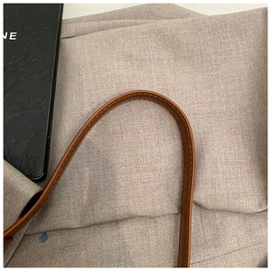 Dettaglio macro delle cuciture precise sulla tracolla in pelle marrone di lusso