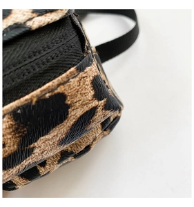 Detailed macro view of the leopard print faux leather texture and sturdy black stitching