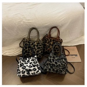 Quatre sacs seaux en peluche à motif léopard en couleurs variées sur sol en bois