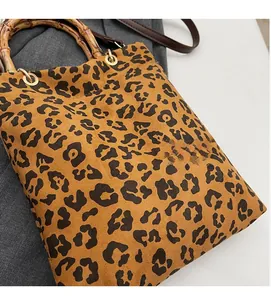 Dettaglio della borsa tote leopardata con manici in bambù naturale e anelli in metallo