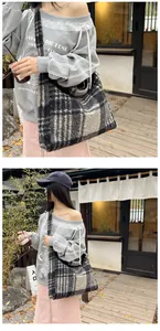 Close-up of a large black and white checkered tweed tote bag with thick woolen texture