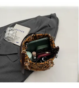 Vista dall'alto dell'interno della borsa a secchiello leopardata con tablet e oggetti