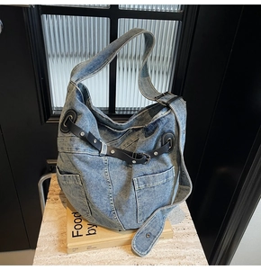 Nahaufnahme der Vintage Denim Hobo-Tasche mit Metallschnallen und Lederriemen