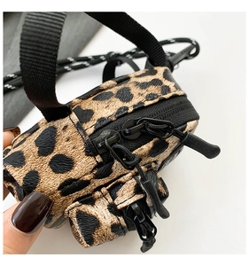 Macro detail of mini leopard print crossbody bag with dual zippers and nylon lanyard