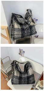 Macro view of textured plaid pattern and adjustable metal buckle on a tote bag