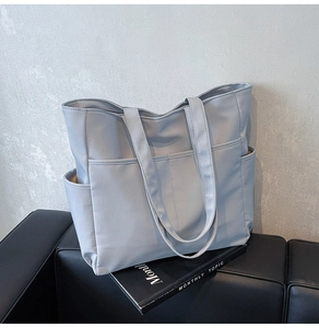 Détail du grand sac cabas en nylon avec poches latérales et bandoulière réglable