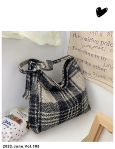 Detail of black and white checkered tote bag featuring a textured wool-like fabric surface