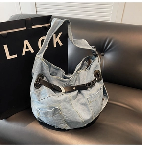Detailansicht der hellblauen Denim-Hobotasche mit schwarzem Ledergürtel und Metallschnallen