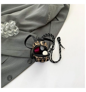 Mini leopard print crossbody bag showing interior storage for lipstick and spray bottle