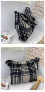 Detail of checkered tweed tote bag showing thick wool texture and adjustable metal buckle