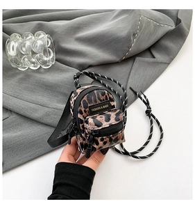 Detail of mini leopard print crossbody bag with woven strap and fashion leather patch