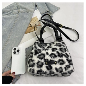 Dettaglio della borsa a secchiello leopardata in peluche con manici in pelle e logo