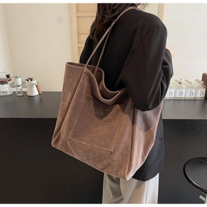 Brown suede tote bag side view on model showing soft texture and large capacity