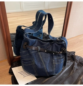 Detailansicht der Vintage-Denim-Tasche mit gelben Kontrastnähten und Lederriemen