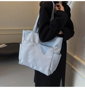 Vue détaillée d'un grand sac cabas bleu montrant plusieurs poches et un tissu résistant