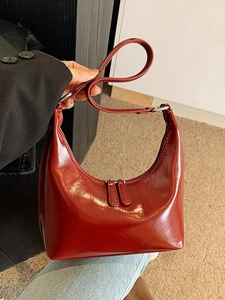 Borsa hobo minimalista in vernice rossa con finitura lucida e anelli argentati