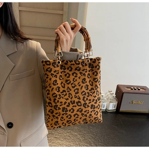 Dettaglio della borsa shopper leopardata retrò con manici in bambù e finiture dorate