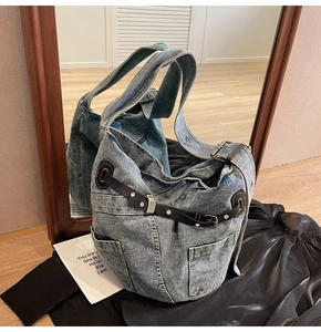 Detail der Vintage-Jeans-Tragetasche mit blauem Stoff und Lederriemen-Verzierungen