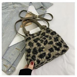 Dettaglio borsa a secchiello in pile leopardato con manico in pelle e rivetti metallici