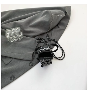 Mini leopard print crossbody bag with rope strap on a suit jacket close-up