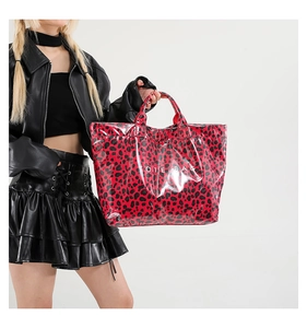 Macro detail of the glossy leopard print texture and white TOTE BAG text on a large tote
