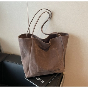 Detail shot of large dark brown suede tote bag with front pocket and slim shoulder straps