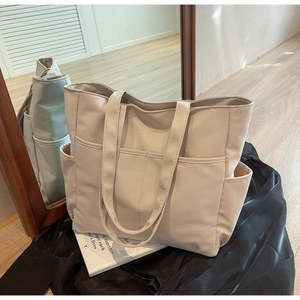 Vue détaillée du grand sac cabas beige en similicuir avec plusieurs poches extérieures