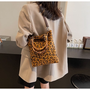 Dettaglio borsa leopardata vintage con manico in bambù e tracolla su una modella