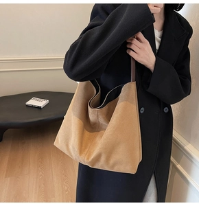 Detail view of a large brown suede hobo bag with adjustable leather shoulder strap