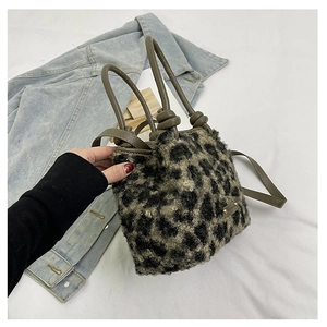 Dettaglio della borsa a secchiello peluche leopardata con manici in pelle e logo