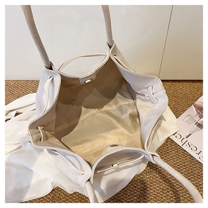 Dettaglio borsa shopper beige con chiusura magnetica in metallo e foulard di seta decorativo