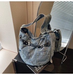 Detail der blauen Vintage-Jeanstasche mit schwarzen Lederriemen und Metallschnallen