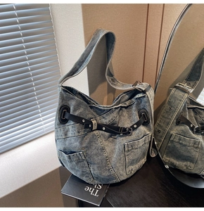 Detailaufnahme der Retro-Denim-Umhängetasche mit Lederriemen und silbernen Metallschnallen